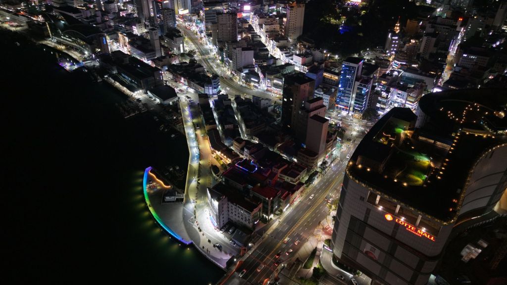 Aerial night view of a Busan road interchange with car light trails