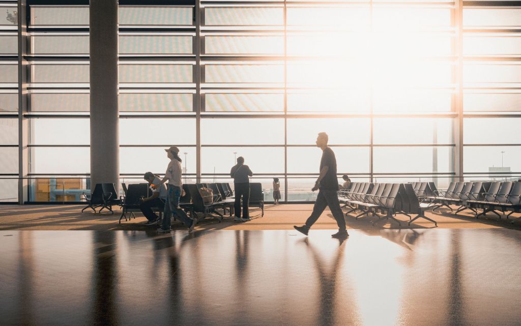 공항 터미널 도착층에서 캐리어를 끌고 나오는 여행자들