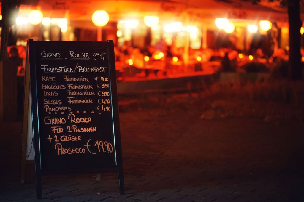 Chalkboard menu with prices outside a restaurant