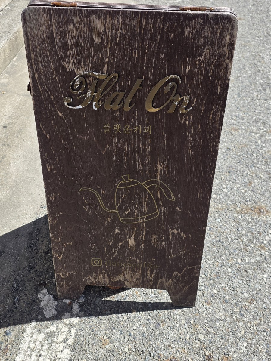 플랫온커피 입간판. 가게 이름과 인스타그램 flatoncoffee 주소가 적혀 있다