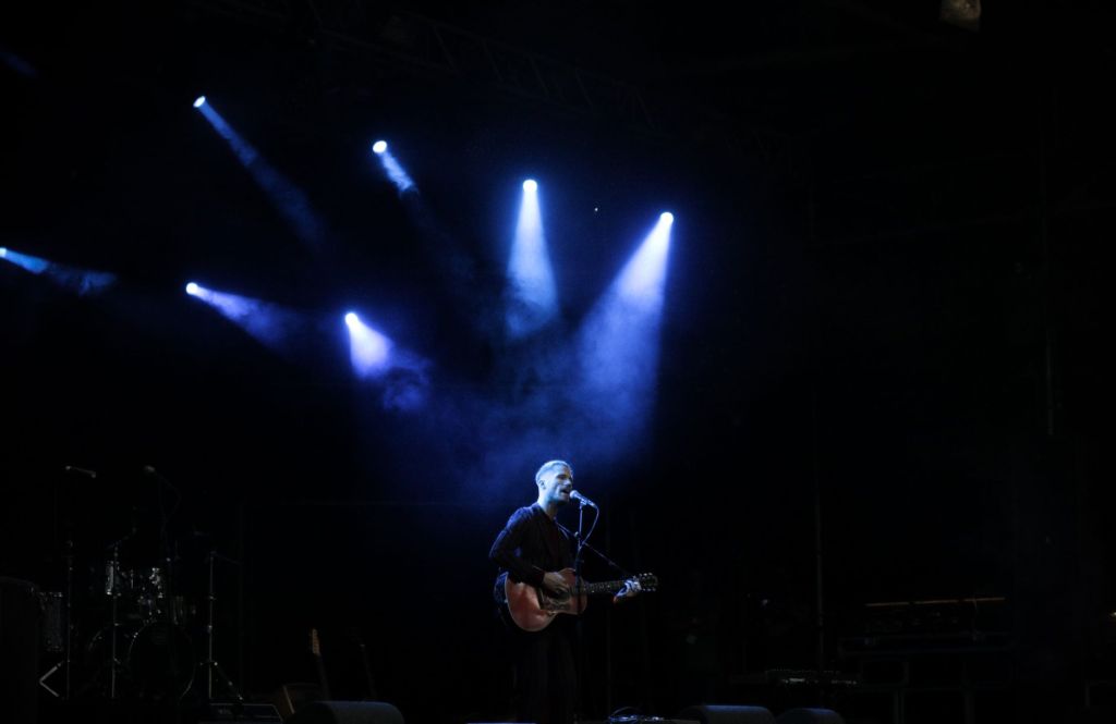 푸른 조명 아래 기타를 메고 노래하는 무대 — AKMU 〈소문의 낙원〉 지방 공연