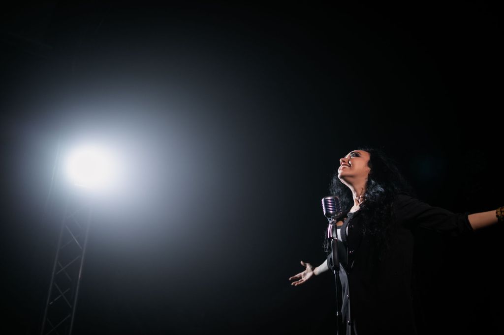 어두운 무대에서 조명을 받으며 노래하는 가수 — 이승철 40주년 〈THE VOICE〉 투어